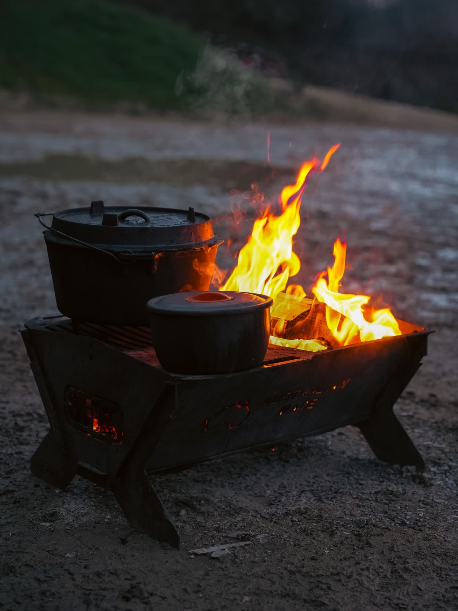 Gruppe von Menschen sitzt in warmer Nachtstimmung um ein offenes Lagerfeuer